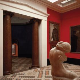 En kunsthal med røde vægge, massive port og klinkegulv