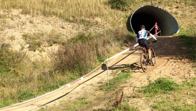 En cykelrytter til mountainbikeløb på vej ind i en tunnel.