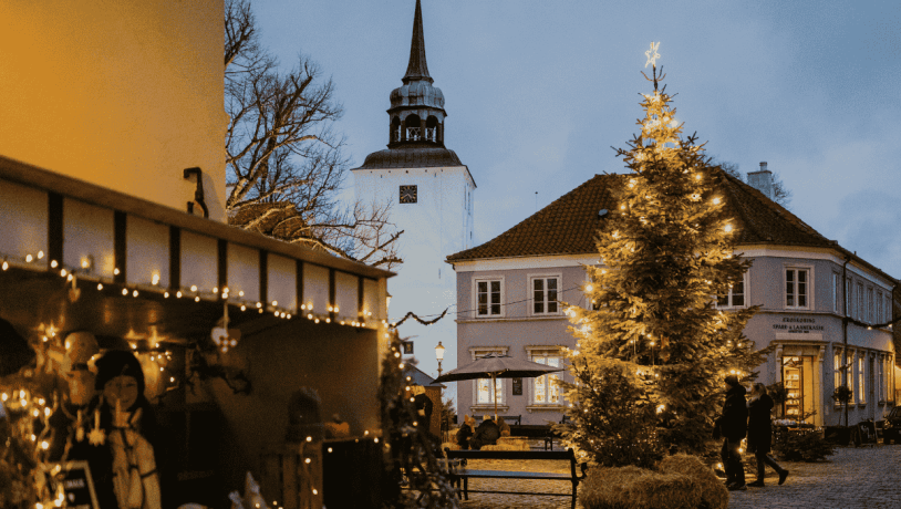 Et bytorv med juledekoration i form af julelys, juletræ og julemarkedboder