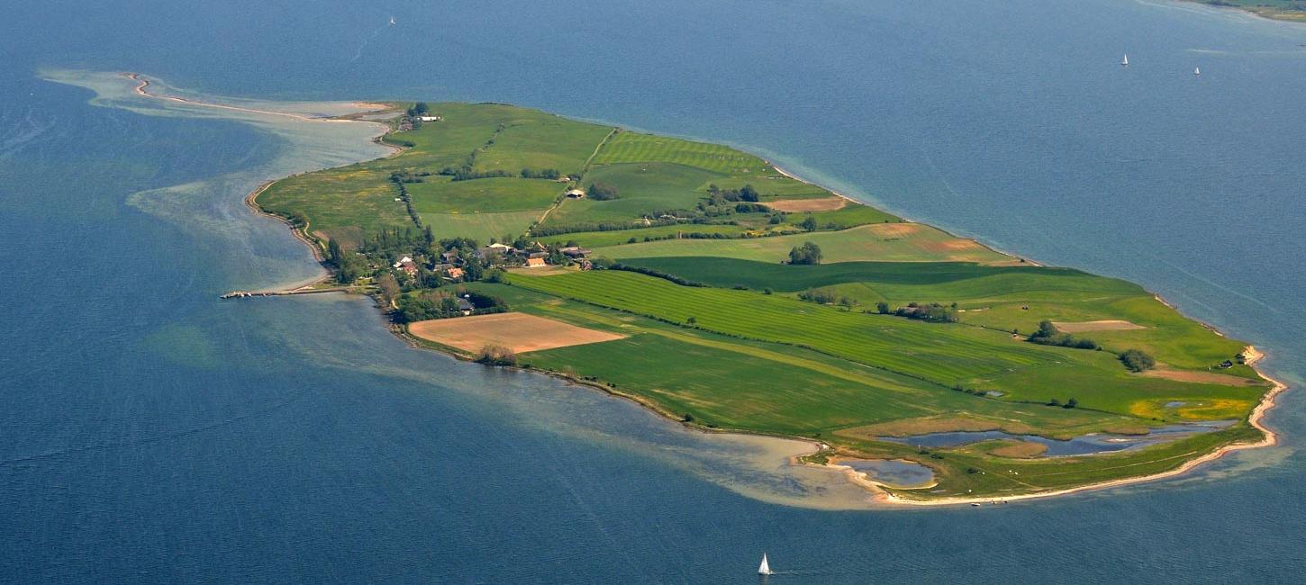 Bjørnø set fra luften, omkranset af vand til alle sider.