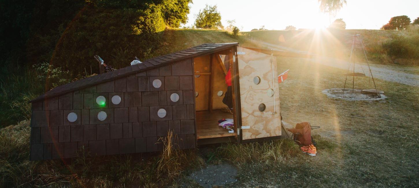 Shelter omringet af naturlige omgivelser. Flot solskin i baggrunden.