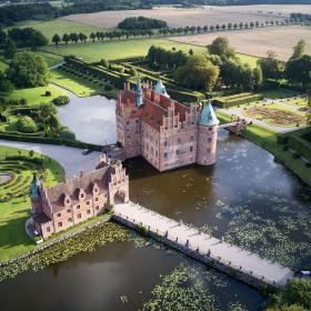 Dronefoto af Egeskov Slot med voldgrav og grønt omkring