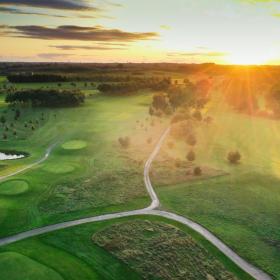 Odense Eventyr Golf set oppefra med solopgang i baggrunden